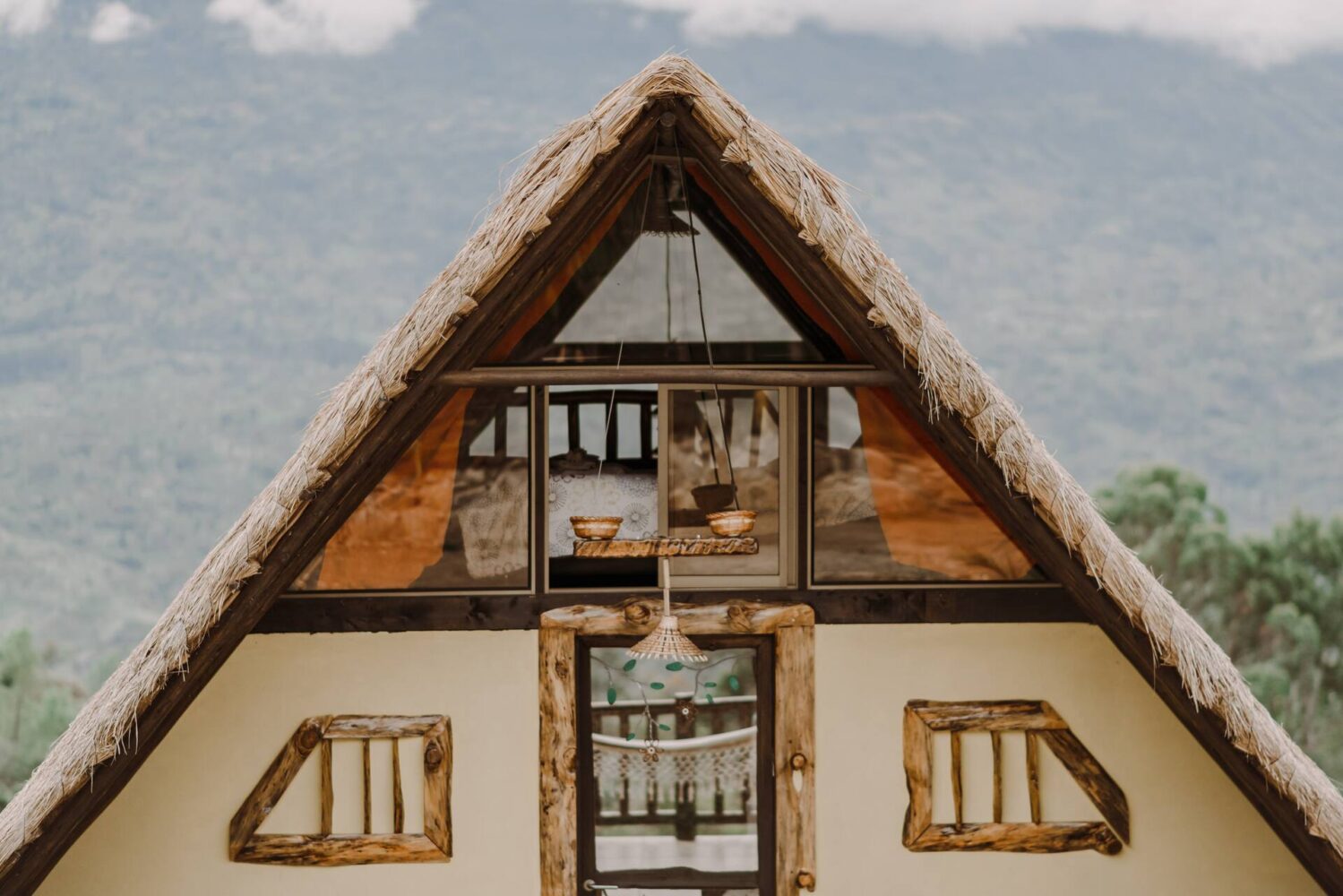 Fachada del Chalet de Paja con su techo de paja y el valle al fondo