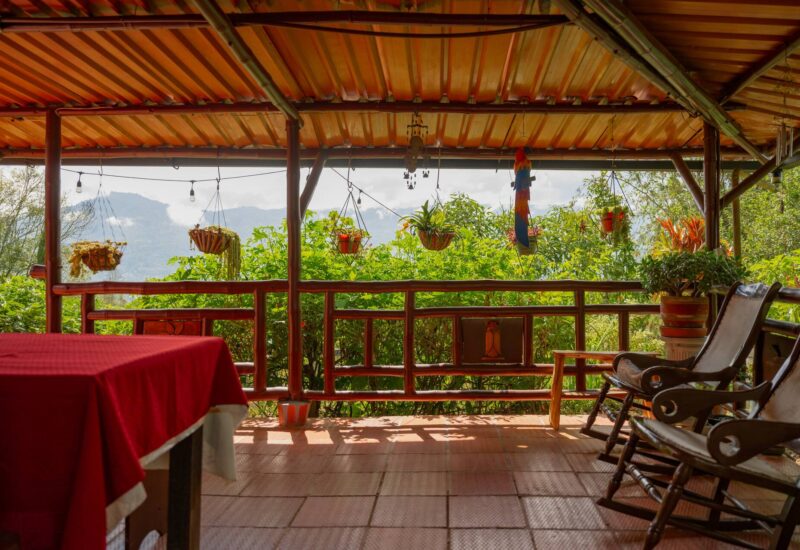 Terraza de La Casa Colonial con mesa y mecedoras